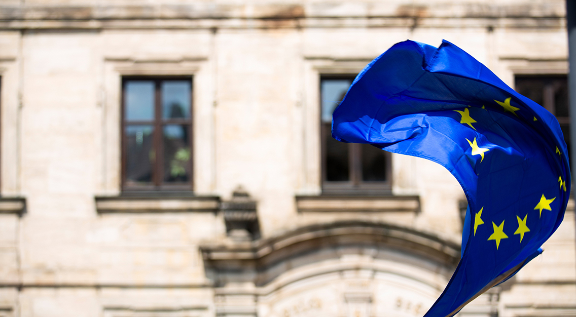 EU:s flagga framför en äldre byggnad.