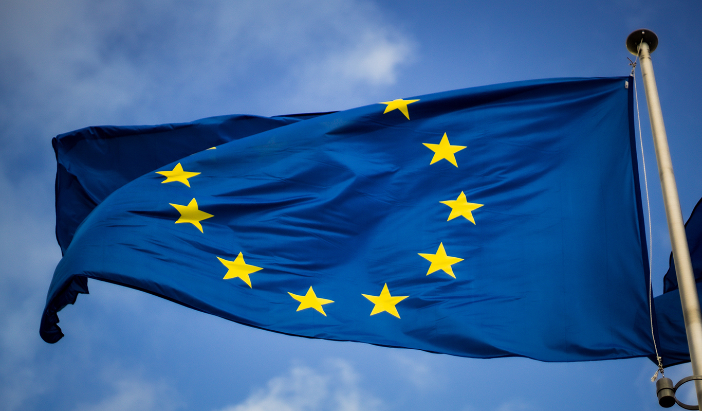 En EU-flagga som fladdrar mot en blå himmel.